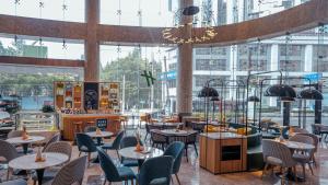 a restaurant with tables and chairs in a building at Holiday Inn Shanghai Nanjing Road by IHG in Shanghai
