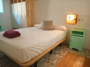 1 dormitorio con 1 cama grande y mesita de noche verde en The Light appartment Tarragona, en Tarragona