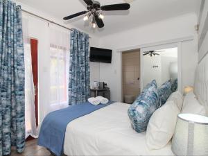 sypialnia z łóżkiem i wentylatorem sufitowym w obiekcie Glennies Guesthouse w mieście Somerset West