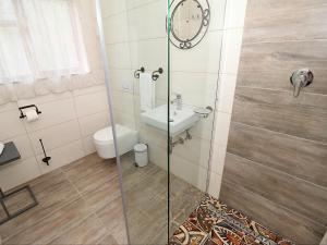 W łazience znajduje się prysznic, toaleta i umywalka. w obiekcie Glennies Guesthouse w mieście Somerset West