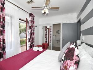 sypialnia z łóżkiem i wentylatorem sufitowym w obiekcie Glennies Guesthouse w mieście Somerset West