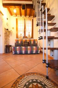 ein Wohnzimmer mit Sofa und Treppe in einem Haus in der Unterkunft Piccola casetta toscana in Pisa