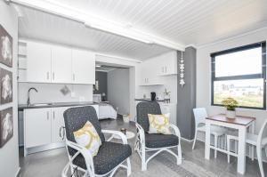 a kitchen and living room with chairs and a table at Hip-Nautic in Yzerfontein +9 photos