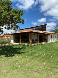 a house with a grass field in front of it at Casa de Campo em cond Villas de Areia prox engenho in Areia