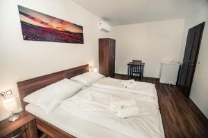 a large white bed with two white towels on it at Penzion Třetí frejd in Bořetice