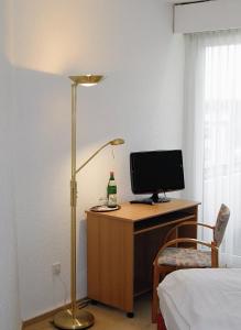 een slaapkamer met een bureau met een computer en een lamp bij Hotel Deisterblick in Bad Nenndorf