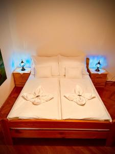 a bed with white sheets and white pillows at Green Apartman in Eger