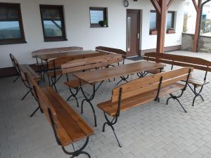 a group of wooden tables and benches in a room at Penzion Třetí frejd in Bořetice