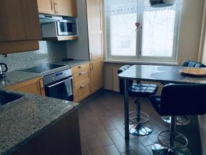 a kitchen with a table and some chairs in it at FlatsinRoi Apartments in Rovaniemi +7 photos