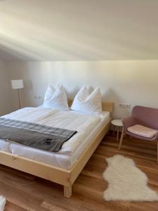 um quarto com uma cama, um sofá e uma cadeira em Naturpark Appartment em Ratting