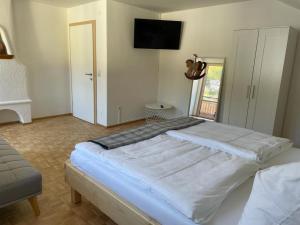 uma cama grande num quarto com uma televisão na parede em Naturpark Appartment em Ratting