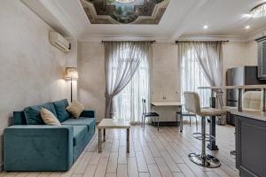 ein Wohnzimmer mit einer blauen Couch und einer Küche in der Unterkunft Vintage Apartments in Odessa