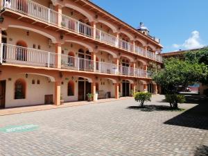 a large building with balconies and a brick courtyard at Hotel Providencia in Talpa de Allende