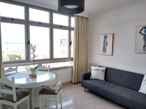 ein Wohnzimmer mit einer Couch und einem Tisch in der Unterkunft Sweet Home Las Canteras in Las Palmas de Gran Canaria