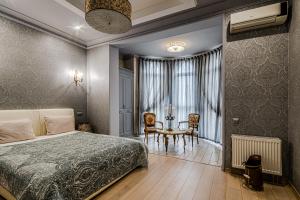 ein Schlafzimmer mit einem Bett, einem Tisch und Stühlen in der Unterkunft Vintage Apartments in Odessa