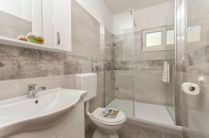 ein Badezimmer mit Toilette, Waschbecken und Dusche in der Unterkunft Apartmani Joško Duće - Omiš in Duće