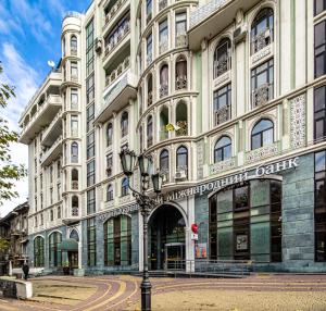 ein großes weißes Gebäude mit Straßenbeleuchtung davor in der Unterkunft Vintage Apartments in Odessa