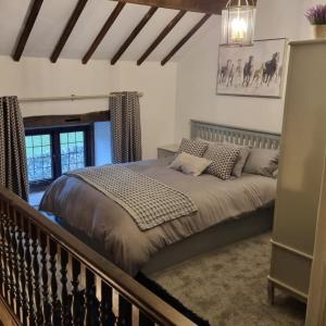 Denver Cottage في Monyash: غرفة نوم بسرير كبير في غرفة