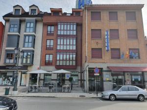 a car parked in front of a building on a street at Idh Angel in Oviedo