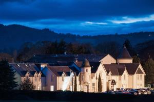 een groot gebouw met auto's geparkeerd voor het bij Kingsmills Hotel in Inverness