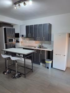 a kitchen with a table and a white refrigerator at Loft CENTRO Con Parking privado GRATIS in Talavera de la Reina +5 photos