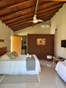 a bedroom with a large bed and a ceiling at Pousada Maritacas do Sana in Sana