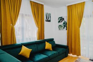 锡纳亚HUGO MOUNTAIN的客厅配有绿色沙发和黄色窗帘