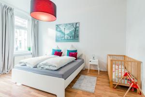 een slaapkamer met een bed met rode en blauwe kussens bij Helle Wohnung mit Balkon in grünen Innenhof - W-LAN, 4 Schlafplätze in Maagdenburg