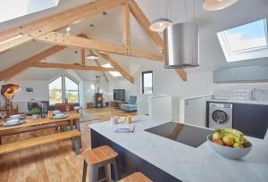 a kitchen and living room with wooden beams at Birch House in St. Agnes
