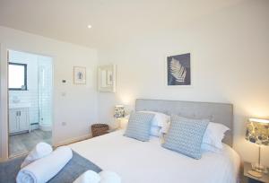 a bedroom with a large white bed with blue pillows at Birch House in St. Agnes