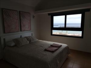 a bedroom with a bed with a view of the beach at CITY&SEA in Arrecife