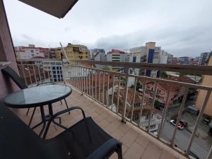 a balcony with a table and a view of a city at City View - Downtown Apartment in Prishtina in Pristina