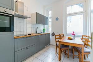 een keuken met een tafel en een eetkamer bij Helle Wohnung mit Balkon in grünen Innenhof - W-LAN, 4 Schlafplätze in Maagdenburg