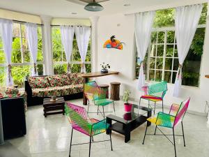 uma sala de estar com cadeiras coloridas e uma mesa em MAHALO HOUSE B&B - Tu Casa Hospedaje en San Andrés Isla - em San Andrés