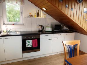 a kitchen with white cabinets and a stove top oven at Schöne Aussicht in Bad König