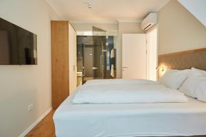 a bedroom with a large white bed and a bathroom at Green Leisure Apartments Schweglerstrasse in Vienna