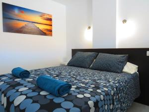 a bedroom with a bed with blue pillows at Near the sea Las Arenas in Playa del Ingles