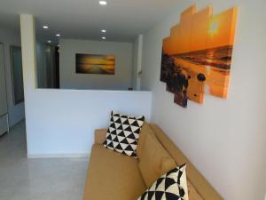 a living room with a couch and paintings on the wall at Near the sea Las Arenas in Playa del Ingles