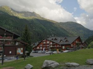a town in the mountains with cars parked on the street at Studio Les Contamines Montjoie - Les Combettes - Le Lay - WIFI INCLUS in Les Contamines-Montjoie