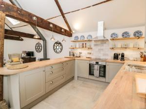 una grande cucina con armadi bianchi e bancone di The Old Swill House a Chippenham