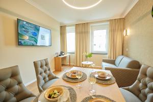 a living room with a table and chairs and a tv at Green Leisure Apartments Schweglerstrasse in Vienna