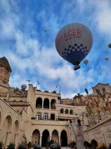 una mongolfiera che vola sopra un edificio di Medusa Cave Hotel a Göreme