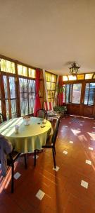 a dining room with a table and chairs and windows at Casona LA FLORIDA con parque y pileta, a una cuadra del río in Rosario
