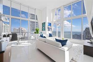 ICONIC LUXURIOUS HIGH CEILINGS UNIT BRICKELL w في ميامي: غرفة معيشة بأثاث أبيض ونوافذ كبيرة