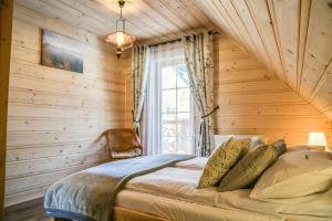 - une chambre avec un lit dans une pièce en bois dans l'établissement Domki 4 Seasons Zakopane, à Zakopane