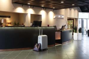 a suitcase is sitting next to a counter in a store at Scandic Aarhus Vest in Aarhus