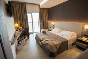 um quarto de hotel com uma cama grande e uma janela em Hermitage Hotel em Silvi Marina