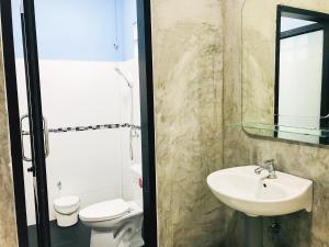 La salle de bains est pourvue d'un lavabo et de toilettes. dans l'établissement ใสโพธิ์โฮมสเตย์, à Phatthalung