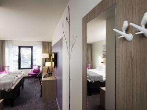 ナルヴィクにあるスカンディック ナルビクのベッド2台と鏡が備わるホテルルームです。