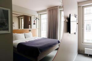 ein Hotelzimmer mit einem Bett und einem Spiegel in der Unterkunft Scandic No 53 in Stockholm